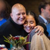 Two guests at dedication sharing a hug